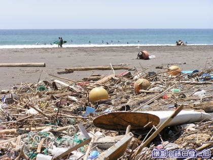 台風で打ち揚がった大量のゴミとサーファー