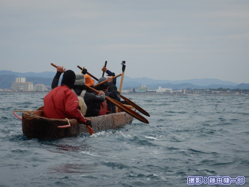 写真：館山市街を背景にした丸木舟。